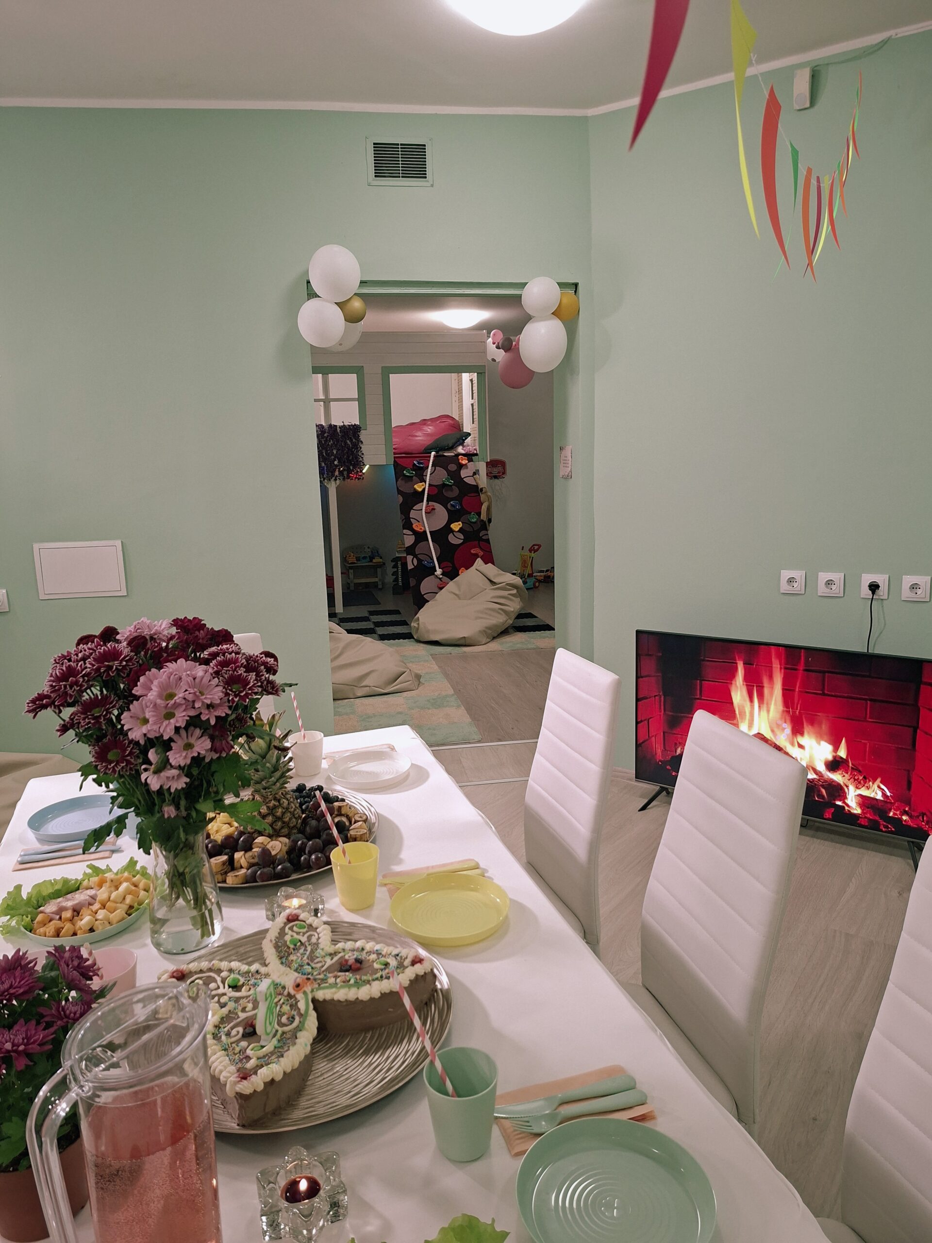 Sünnipäevalaud kamina ja lilledega Feya mängutoas